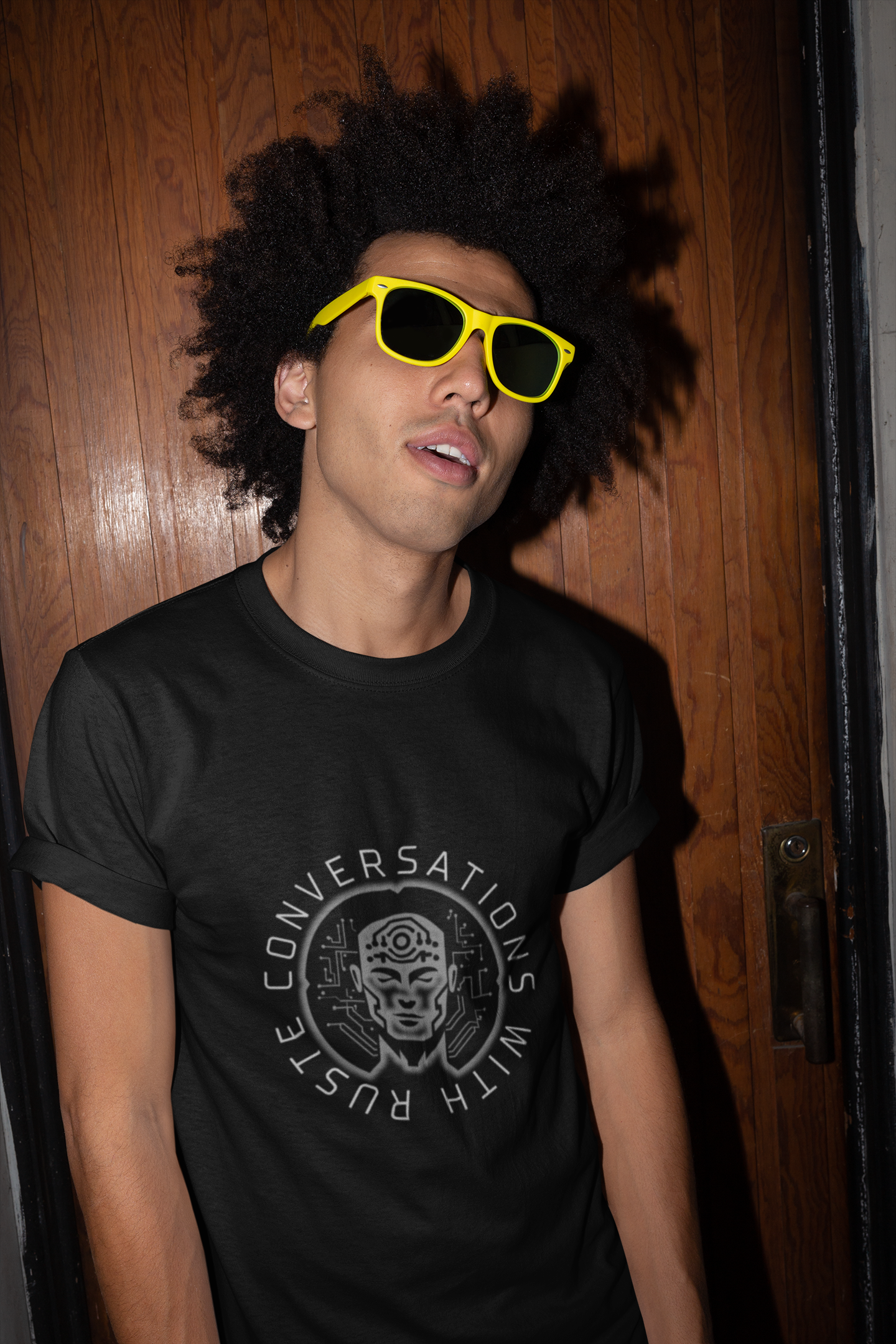tshirt-mockup-of-a-man-with-sunglasses-against-a-wooden-door-22298